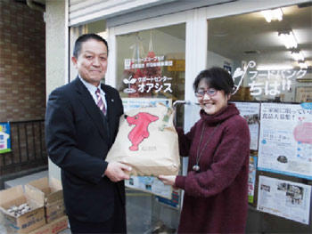 出品米を手渡す谷米穀部長(左)の内容を表示