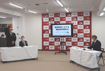 小林本部長(左)が今年度の補助教材を紹介の内容を表示