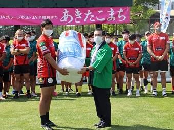 木元次長（右）から齋藤共同主将へ牛乳瓶のクッションを贈呈の内容を表示