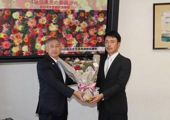 猿田副知事（左）へ花束を手渡す田村副会長の内容を表示