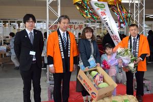 300万人目の金子さん親子に記念品が贈呈されました。（左より、佐藤園芸直販課長、渡部県副本部長、金子さん親子、小山愛情館出荷者協議会会長）の内容を表示
