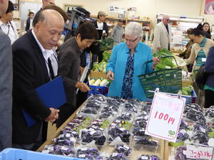 買い物カゴを手に持ち、自ら果物を購入するジーナ・マッカーシー長官（左より3番目）の内容を表示