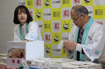 当選者を選ぶ藤川さん(左)と西村県本部長(右)の内容を表示
