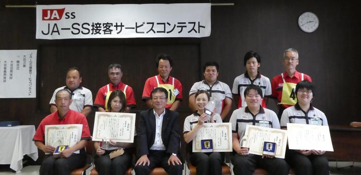 コンテスト出場選手と藤井松太郎協議会会長(1列目は入賞者:左から、安江将年さん、佐藤藍さん、松井会長、田口純子さん、神出和樹さん、向畑伶香さん) の内容を表示