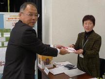 寄付金を手渡す西村副本部長（左）の内容を表示
