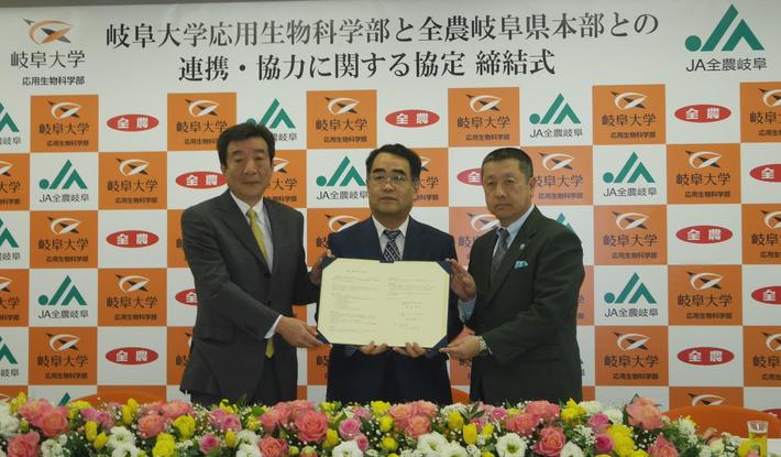 協定書を手にする（左から）桑田県本部長、福井学部長、高木農政部長の内容を表示