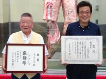 飛騨牛フェスタin飛騨で最優秀賞を受賞した出品者の有限会社武藤畜産(右)と、購買者の株式会社丸明(左)の内容を表示