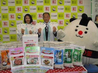左から順に「ぎふの米」メッセンジャーの藤川さん、西村副本部長、イメージキャラクターのぎふマイの里の内容を表示