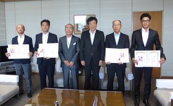 研修を修了した４人と桑田県本部長（中央右）と研修指導管理者（中央左）の内容を表示