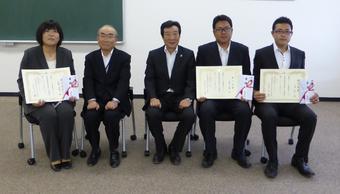 研修を修了した３人と桑田県本部長（中央）と研修指導管理者（左から2人目）の内容を表示