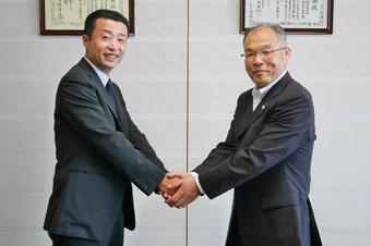 岐阜県産青果物の販売拡大に向け、握手を交わす藤井社長（左）と西村県本部長（右）の内容を表示