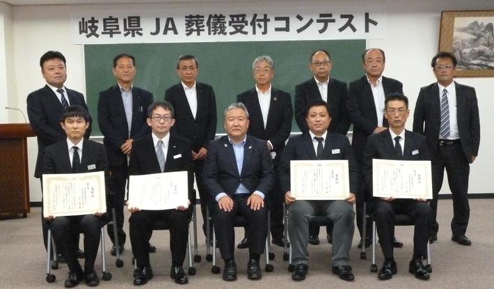 最優秀賞の太田さん(前列右から2人目)と優秀賞の児山さん(前列左から2人目)と優良賞の石原さん(前列右)、同じく優良賞の吉岡さん(前列左)・審査員の方々(後列)の内容を表示