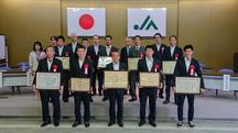 表彰された生産者(前2列)と主催者の内容を表示