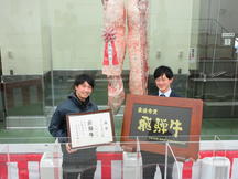 購買者の㈲ながせ食品(左)と最優秀賞を受賞した㈲牛丸畜産の内容を表示