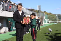 優勝チームの選手へ「美濃娘」を贈る伊藤副本部長（左）の内容を表示
