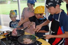 厚みのある県産豚肉を豪快に焼く参加者たちの内容を表示