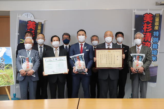 鈴木知事（中央）に受賞を報告した関係者の内容を表示