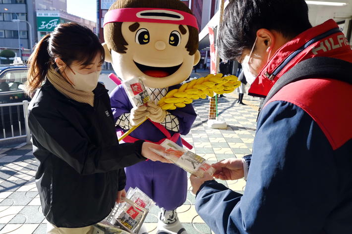駅利用者に「伊賀米」を手渡してPRする関係者の内容を表示