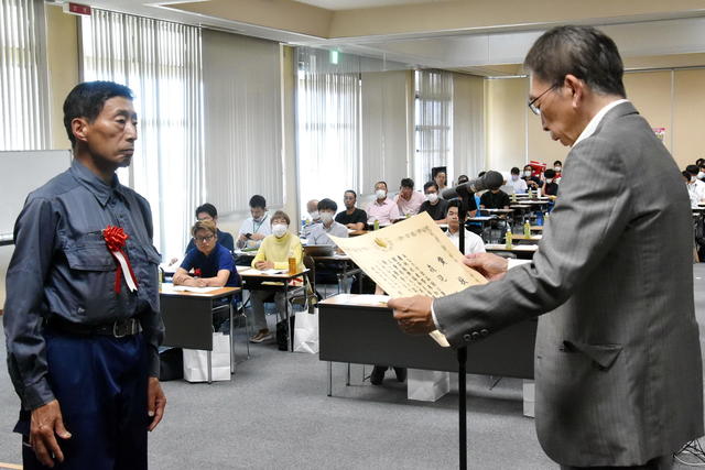 大臣賞の表彰を受ける森見さん（左）の内容を表示