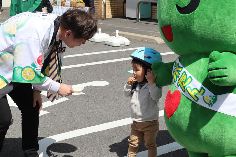 ◆試食宣伝をする佐土原斉副本部長（㊧）の内容を表示