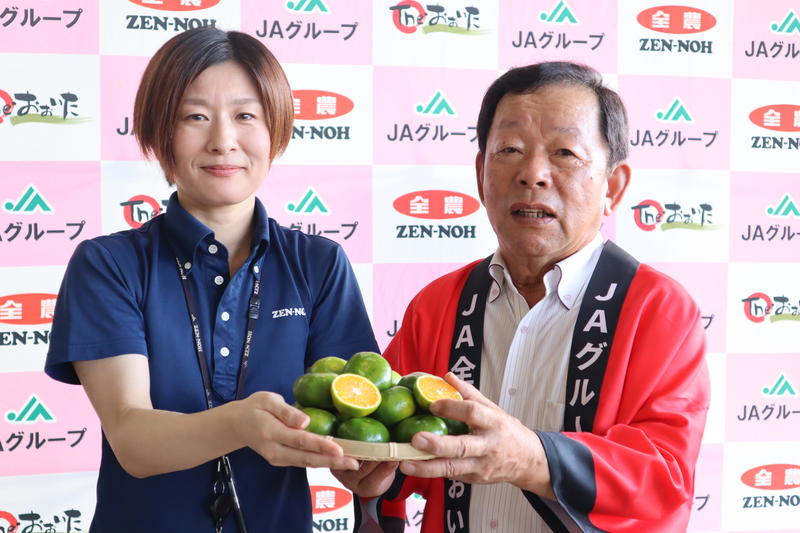 ◆おおいた早生を持つ木村会長（㊨）、園芸販売課職員（㊧）の内容を表示