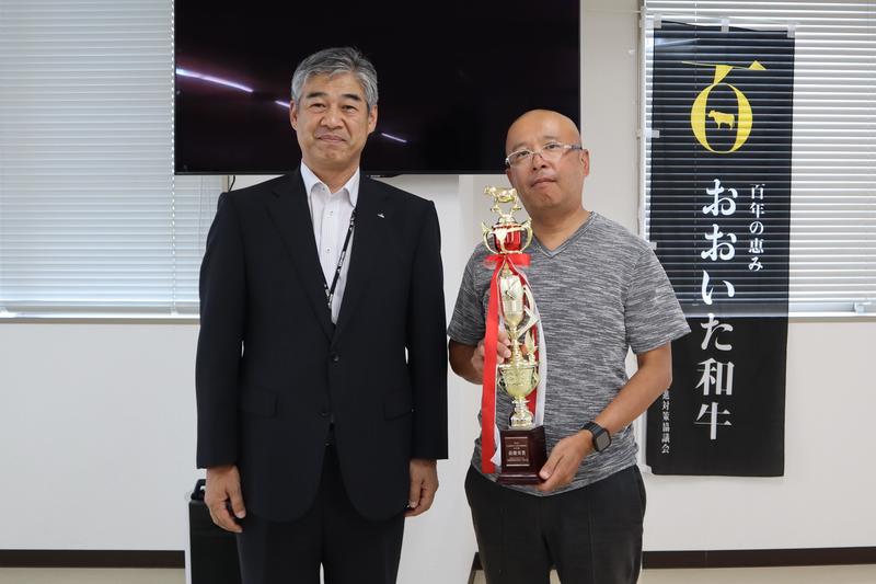 ◆和牛の部で最優秀賞を獲得した浦田忠治代表取締役(右)と日野副本部長(左)の内容を表示
