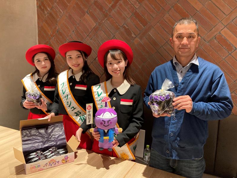 千両なすをPRする千両なす生産者とフレッシュおかやま(左から野村光璃愛さん、横溝結香さん、板谷和胡さん、芳賀部会長)の内容を表示