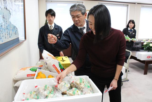 贈呈品の生シイタケを手に取る前田陽子選手の内容を表示