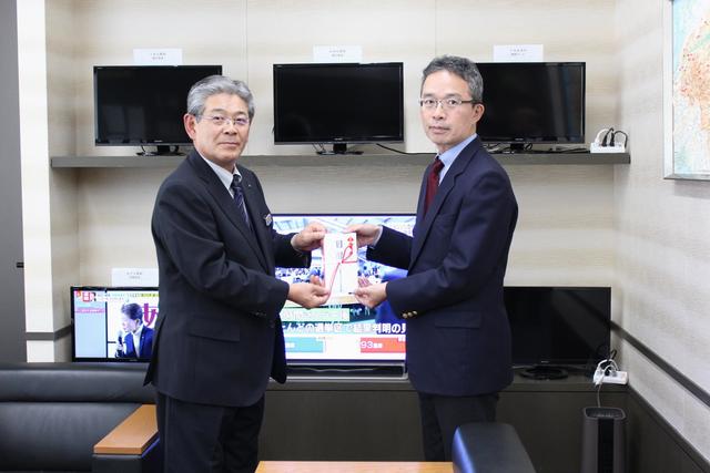 長江郁哉県本部長(左)から、表聖司局長(右)に手渡しましたの内容を表示