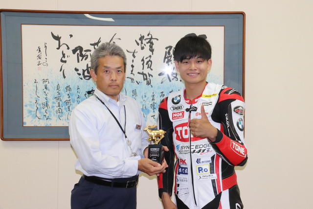 優勝トロフィーを手に記念撮影の内容を表示