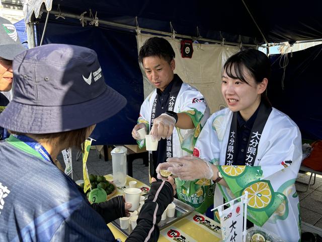 味比べの「大分かぼす」を手渡す大分県本部職員の内容を表示