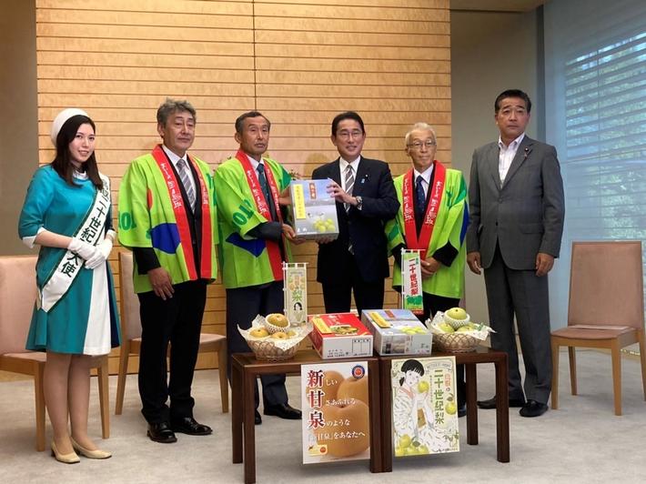 栗原会長から岸田首相へ二十世紀梨の贈呈(左から鳥取県二十世紀梨大使 徳井さん、尾崎県本部長、栗原運営委員会会長、岸田首相、寺地梨果実部協議会会長、藤木参議院議員)の内容を表示
