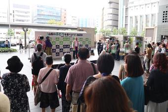 京都駅前広場で大勢の参集者に県産ぶどうをPRの内容を表示