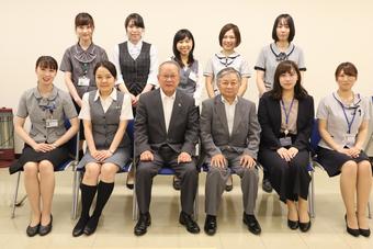 委嘱状交付後、長田会長(中央左)と梶原県本部長(中央右)を囲んで記念撮影の内容を表示