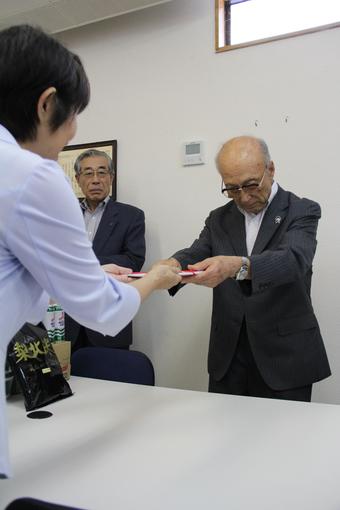 米山理事長に目録を手渡す關本会長の内容を表示