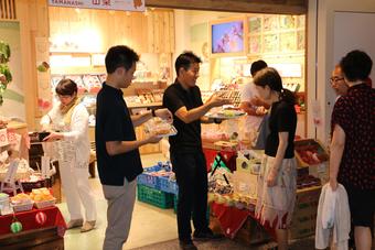 来店者に試食の県産ももを説明する山梨県本部職員の内容を表示