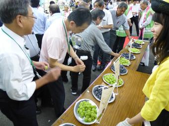 県産ぶどうを試食する市場関係者らの内容を表示