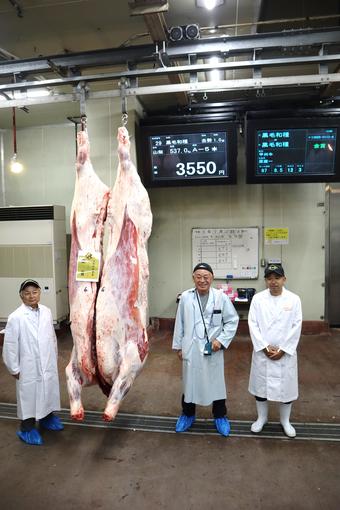 金賞を受賞した肉牛と生産者の原さん(右)、購買者の小島精肉店(中央)、梶原実行委員会会長(左)の内容を表示